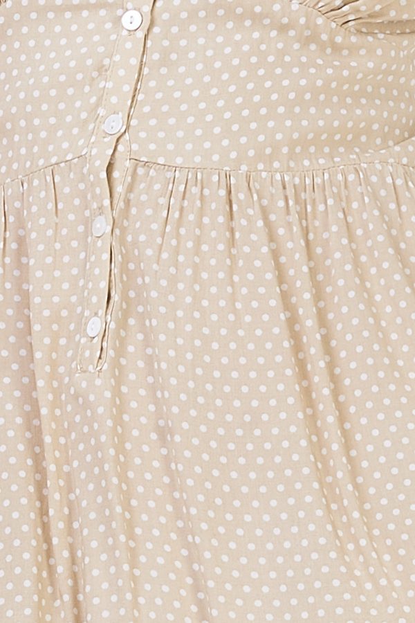 Vestido corto con estampado de lunares. Trae tirantes regulables, escote triangular de pico y elástico estilo nido de abeja