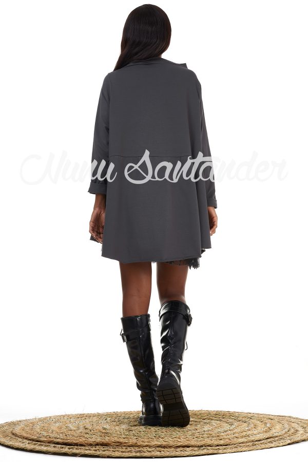 Blusa de algodón con caída asimétrica y detalle de aberturas en ambos laterales. Trae cuello caja y manga larga remangable. Tejido elástico.