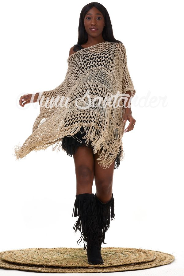Poncho de tejido abierto con hilo metálico. Trae manga con hombro caído y cuello redondo. Detalle de flecos en el acabado. Caída asimétrica.