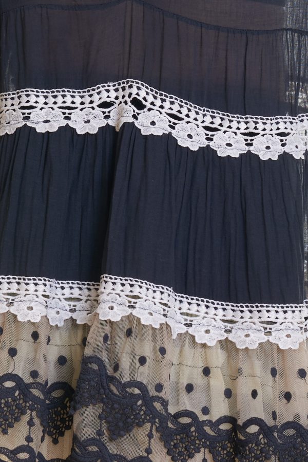 Vestido corto de algodón con encaje. Trae escote en V t manga larga acampanada, con volante al final. No trae forro.