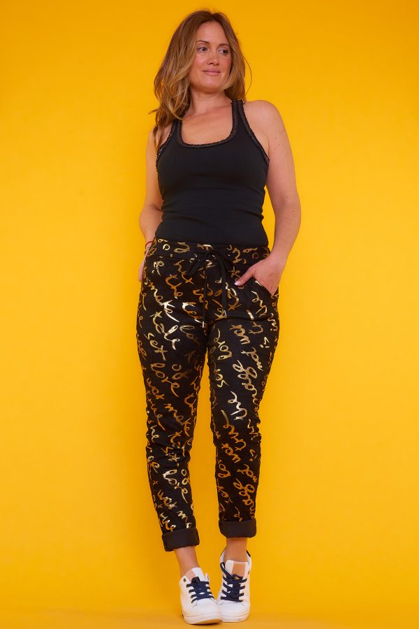 Pantalón Doty: pantalón elástico con detalles dorados brillantes, bolsillos funcionales y cintura ajustable. Diseño moderno, cómodo y sofisticado.