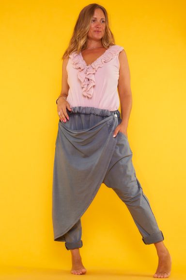 Pantalón elástico estilo baggy gris con solapa frontal ajustable, bolsillos funcionales y cintura elástica. Diseño cómodo y moderno.