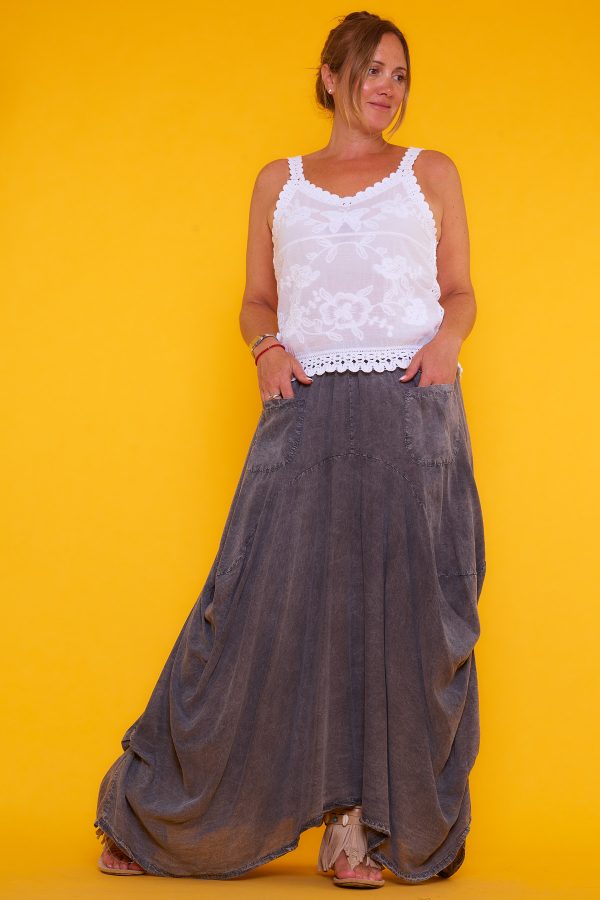 Falda Zulema: falda de Tencel con cintura elástica, corte asimétrico y tono gris desgastado. Tejido antiarrugas, ligero y moderno.