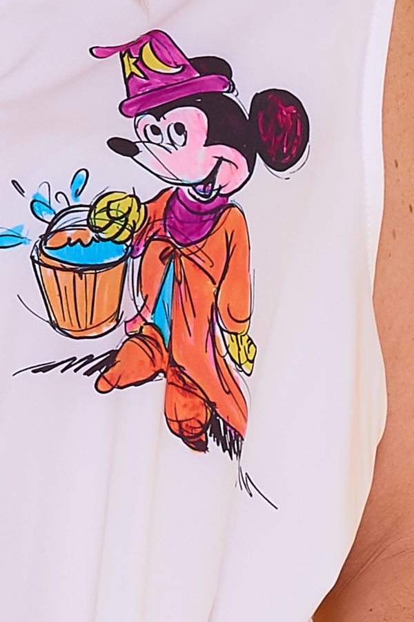 Una camisa sin mangas que tiene botones y cuello. La prenda tiene estampado y una apertura decorativa en sus laterales.