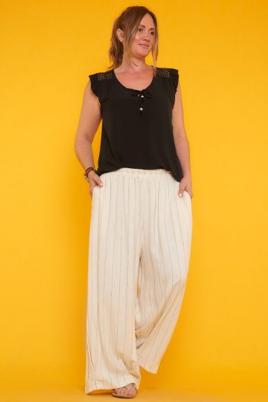 Un pantalón de lino que tiene pierna ancha, bolsillos laterales y una goma elástica en la cintura. Una prenda ideal para la temporada.