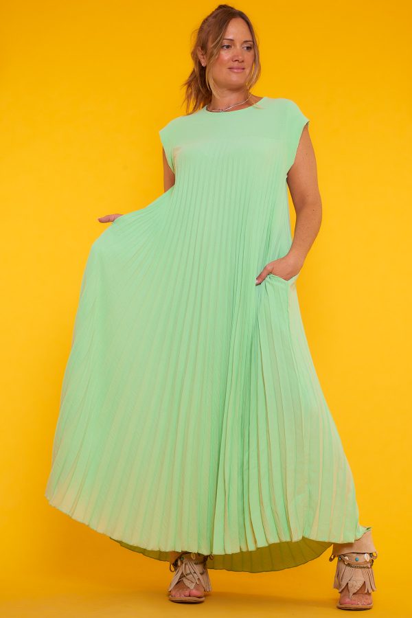Un vestido largo plisado que es elástico y que tiene manga corta. El vestido tiene dos bolsillos en la parte frontal.