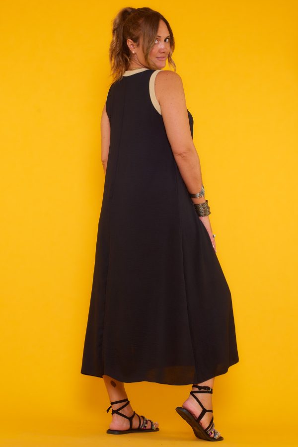 Un vestido largo elástico sin mangas que tiene una apertura en la parte inferior y tiene hilo metálico color dorado en sus bordes superiores.