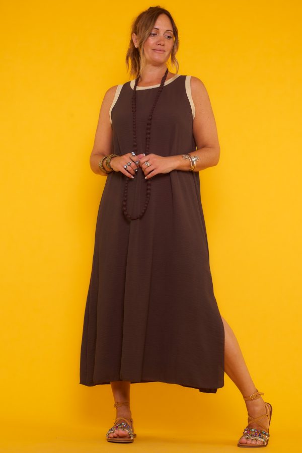 Un vestido largo elástico sin mangas que tiene una apertura en la parte inferior y tiene hilo metálico color dorado en sus bordes superiores.