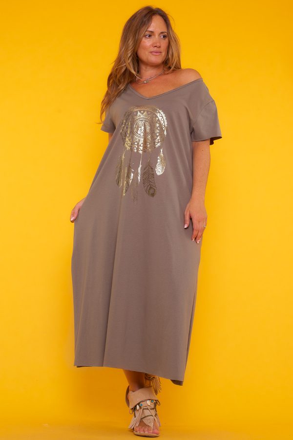 Un vestido largo elástico que tiene manga corta y un escote en pico amplio. Tiene un estampado en la parte frontal y dos aperturas laterales.