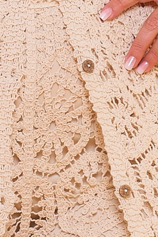Un chaleco elástico de crochet que se caracteriza por ser largo y por tener un diseño original y distintivo. Se cierra por medio de botones.