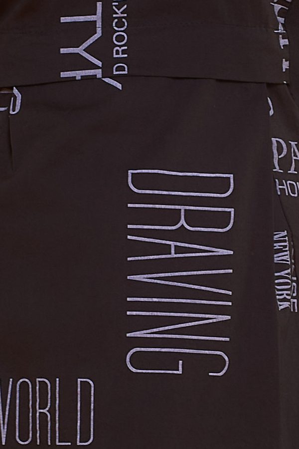 Un vestido corto elástico sin mangas que tiene su estampado de palabras en toda la prenda. Es de corte globo y tiene cintas en la cintura.