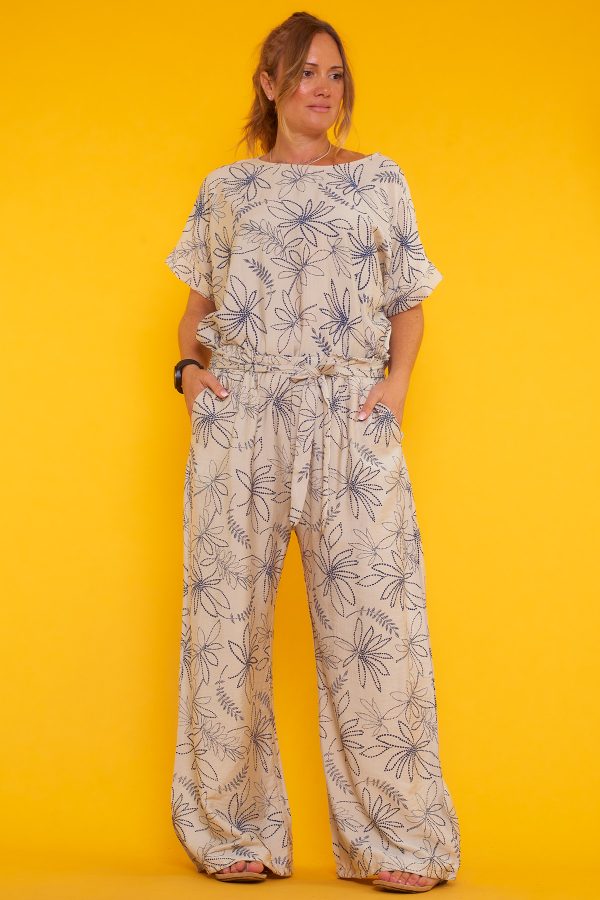 Un pantalón estampado que tiene dos bolsillos laterales y una goma elástica en la cintura. Tiene un par de cintas para hacer nudo decorativo.