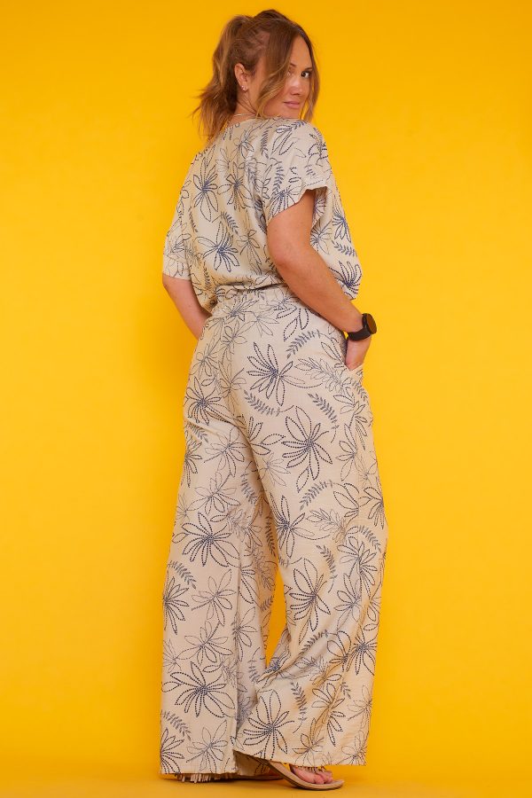 Un pantalón estampado que tiene dos bolsillos laterales y una goma elástica en la cintura. Tiene un par de cintas para hacer nudo decorativo.