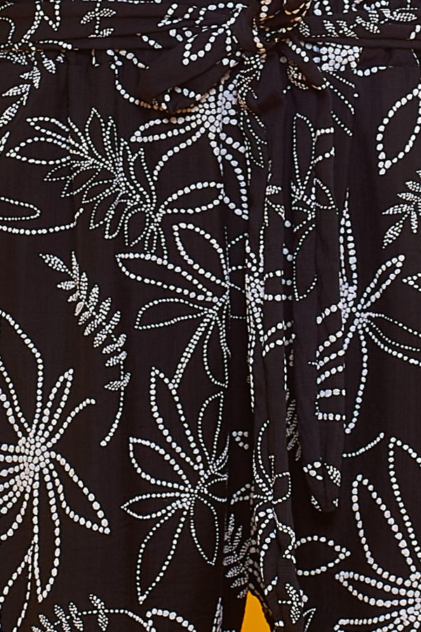 Un pantalón estampado que tiene dos bolsillos laterales y una goma elástica en la cintura. Tiene un par de cintas para hacer nudo decorativo.
