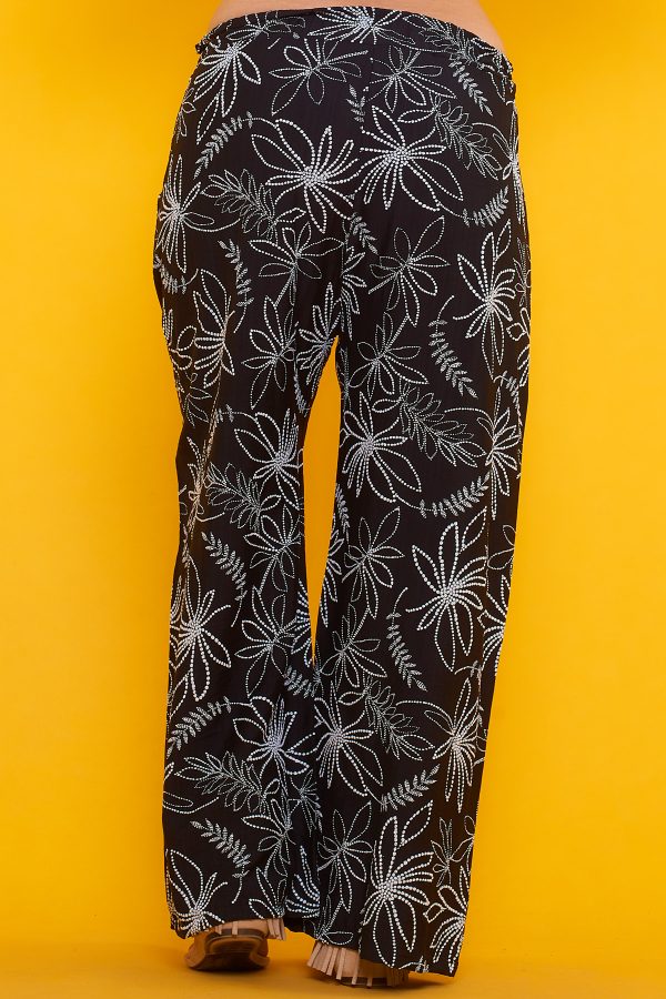 Un pantalón estampado que tiene dos bolsillos laterales y una goma elástica en la cintura. Tiene un par de cintas para hacer nudo decorativo.