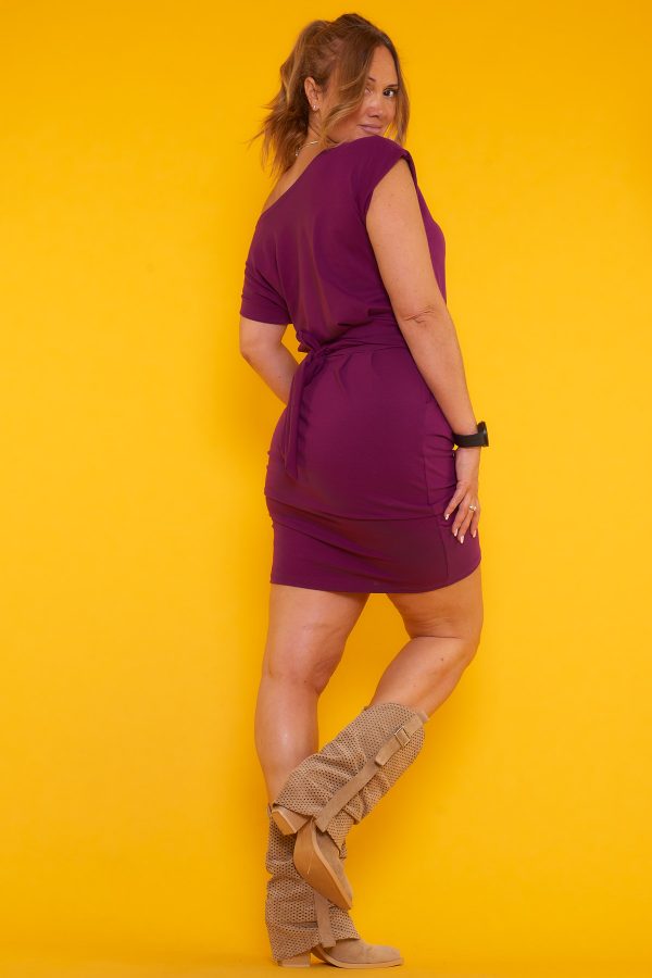 Un vestido corto elástico que tiene dos bolsillos y manga corta. Tiene una cinta de amarre en la cintura para hacer nudo decorativo.