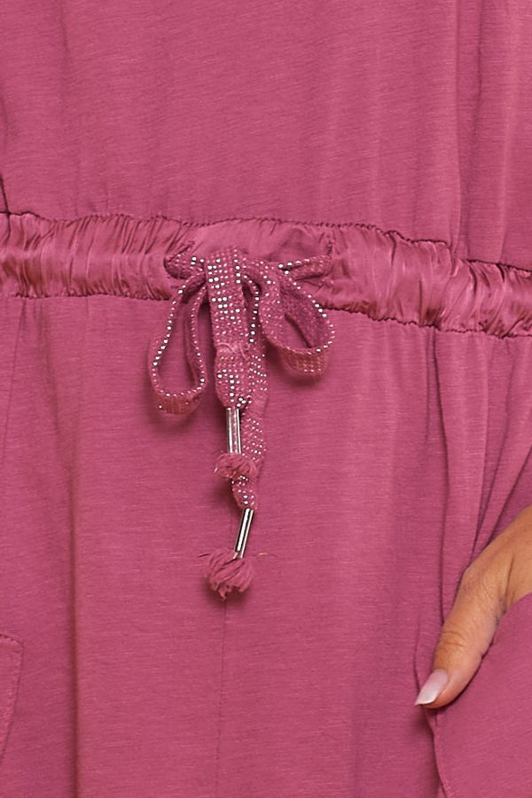 Un mono elástico sin mangas estilo baggy que tiene cuatro bolsillos y una goma elástica en la cintura con cordones.