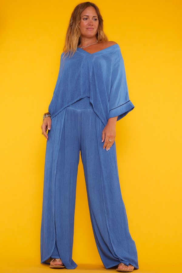 Conjunto compuesto por una blusa manga murciélago con corte japonés y un pantalón con nido de abeja. Ambos tienen tejido de bambula.