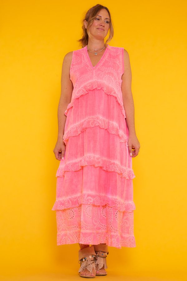 Un vestido largo sin mangas que tiene escote en pico. Se caracteriza por su tono flúor desgastado y sus volantes.