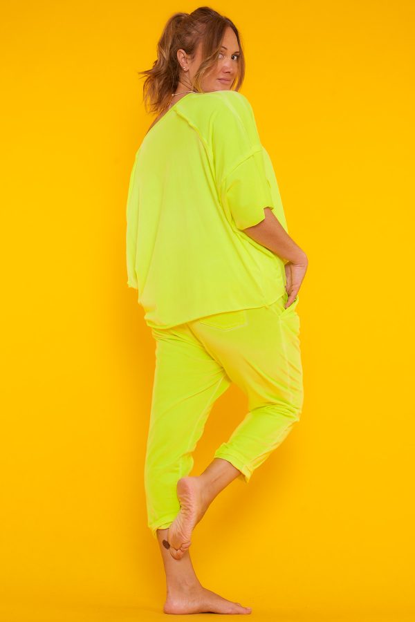 Una blusa elástica estilo oversize con escote en pico y manga murciélago. Tiene estampado y en algunas partes su tejido y tela expuesta.