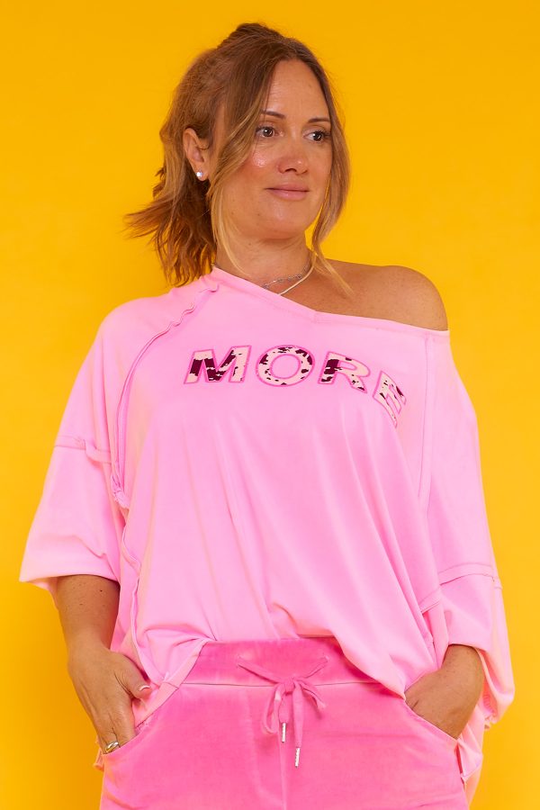 Una blusa elástica estilo oversize con escote en pico y manga murciélago. Tiene estampado y en algunas partes su tejido y tela expuesta.