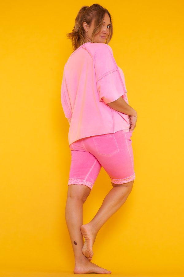 Una blusa elástica estilo oversize con escote en pico y manga murciélago. Tiene estampado y en algunas partes su tejido y tela expuesta.