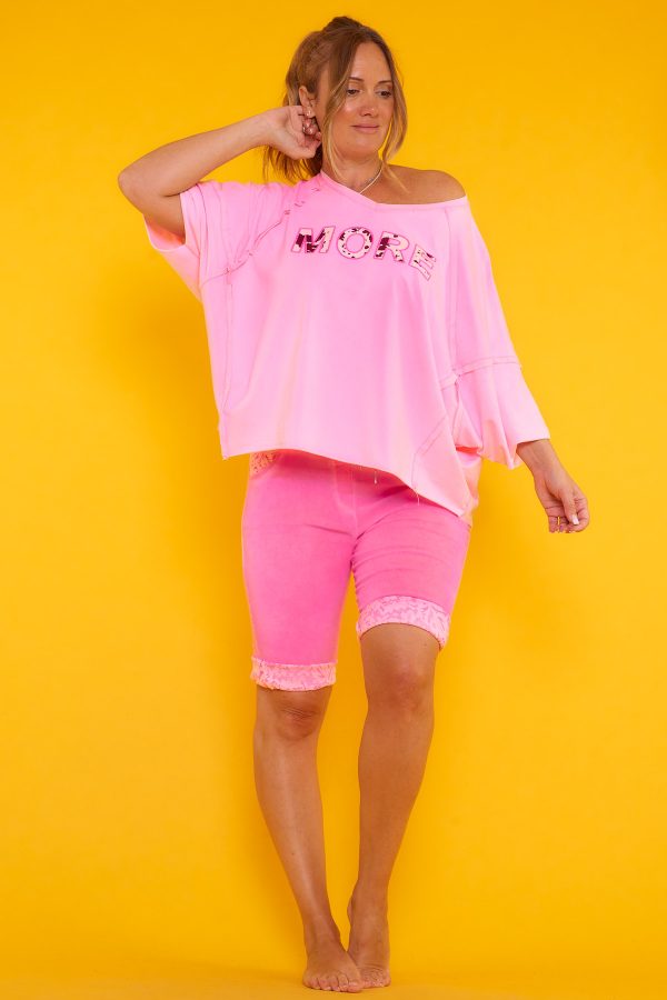 Una blusa elástica estilo oversize con escote en pico y manga murciélago. Tiene estampado y en algunas partes su tejido y tela expuesta.