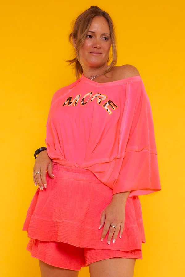 Una blusa elástica estilo oversize con escote en pico y manga murciélago. Tiene estampado y en algunas partes su tejido y tela expuesta.