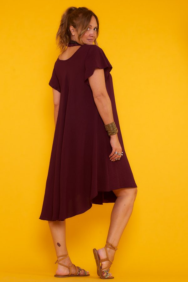 Un vestido corto elástico que tiene escote en pico y una caída muy fluida. La prenda tiene manga corta y un tejido suave y ligero.