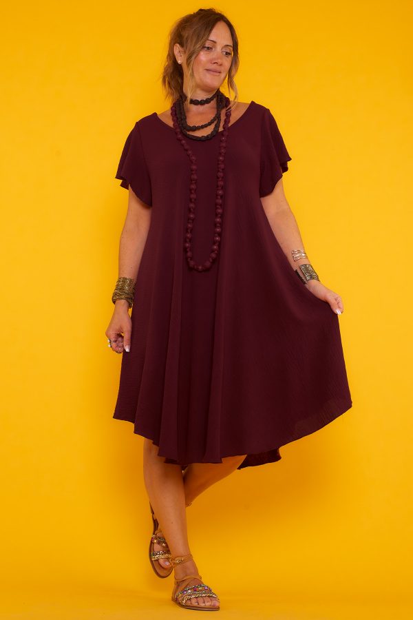 Un vestido corto elástico que tiene escote en pico y una caída muy fluida. La prenda tiene manga corta y un tejido suave y ligero.