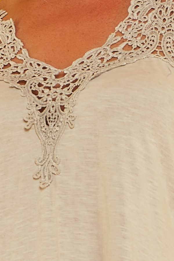 Un vestido corto elástico que tiene diseño de tirantes fijos cruzados en la espalda y detalle de crochet en su escote y parte inferior.