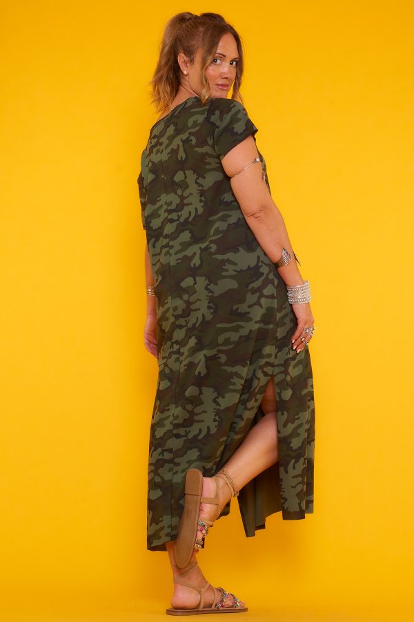 Un vestido largo elástico que tiene manga corta y escote en pico. Tiene una apertura decorativa en uno de sus laterales y estampado militar.