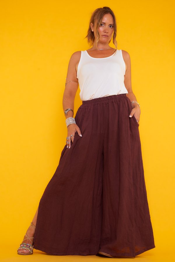 Un pantalón de pierna ancha que tiene dos bolsillos laterales y una goma elástica en la cintura. Tiene aperturas decorativas en sus laterales.