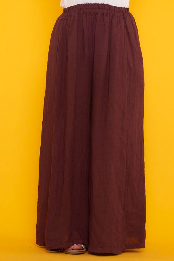 Un pantalón de pierna ancha que tiene dos bolsillos laterales y una goma elástica en la cintura. Tiene aperturas decorativas en sus laterales.