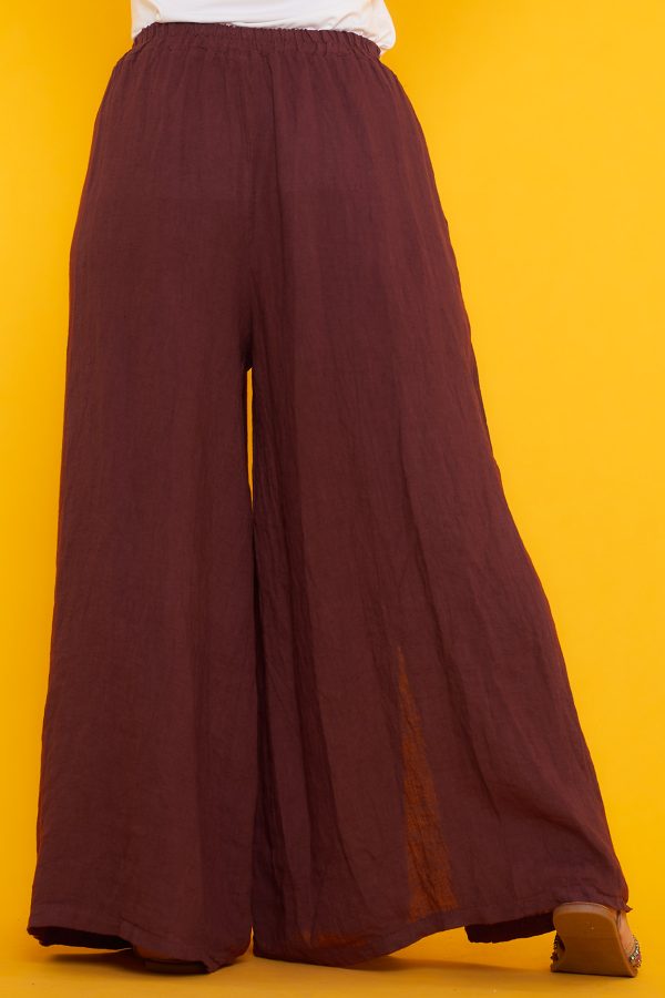 Un pantalón de pierna ancha que tiene dos bolsillos laterales y una goma elástica en la cintura. Tiene aperturas decorativas en sus laterales.