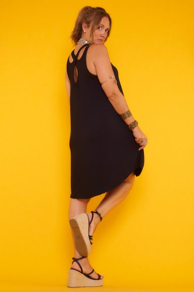 Un vestido corto elástico que tiene un corte asimétrico y se caracteriza por su diseño de tirantes cruzados en la parte trasera. 
