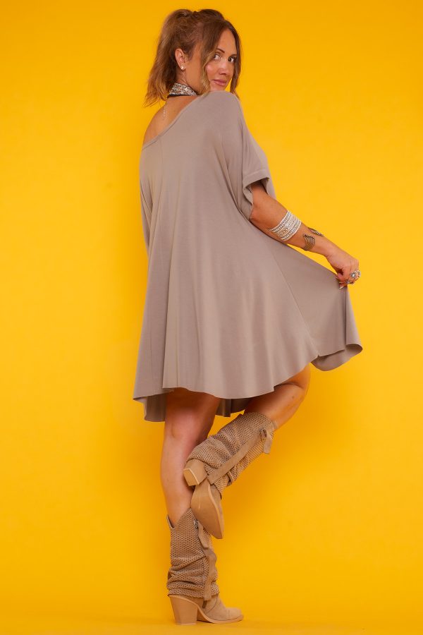 Un vestido corto elástico que viene con un colgante incluido. Tiene un corte asimétrico, un escote amplio y una especie de manga francesa.