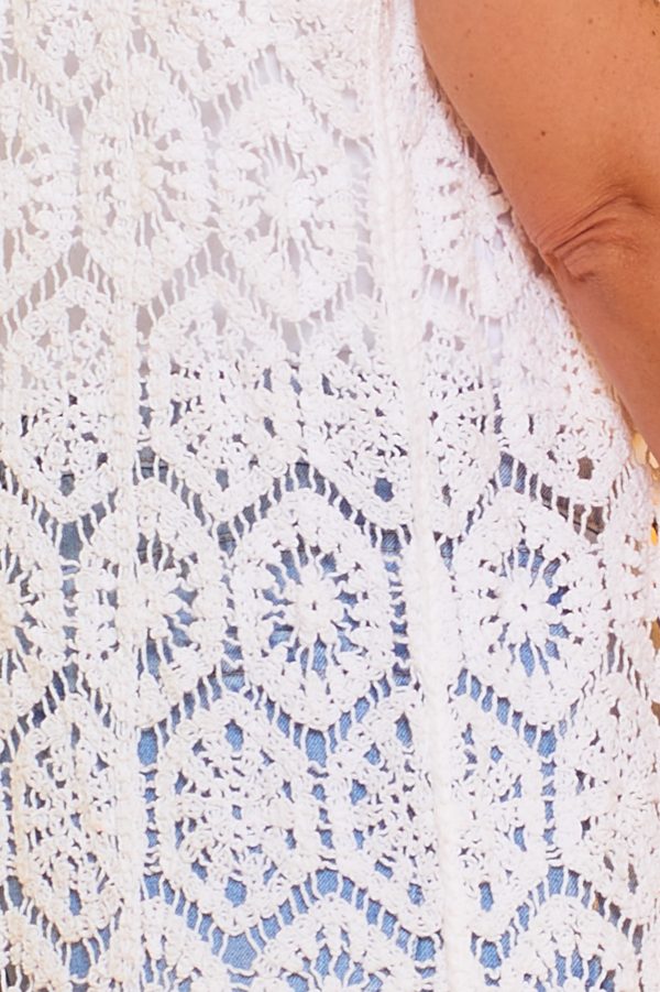 Un chaleco elástico de crochet que se caracteriza por ser largo y por tener un diseño original y distintivo. Se cierra por medio de botones.