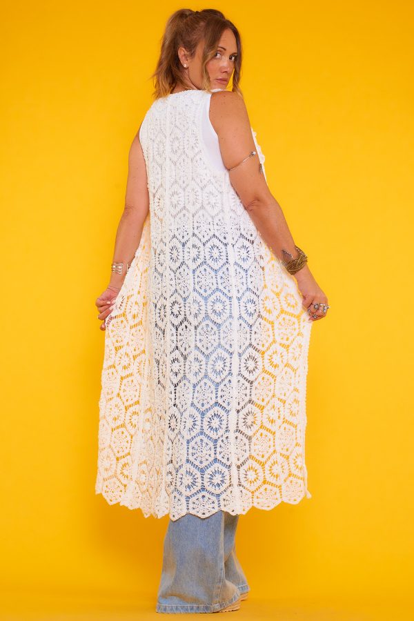 Un chaleco elástico de crochet que se caracteriza por ser largo y por tener un diseño original y distintivo. Se cierra por medio de botones.