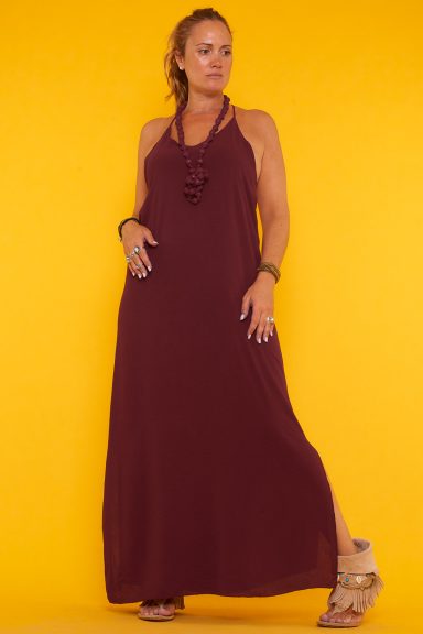 Un vestido elástico que tiene tirantes fijos, espalda descubierta y dos aperturas decorativas. Tiene diseño de argollas en su espalda.