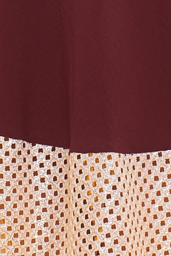 Un vestido largo sin mangas que se caracteriza por sus detalles en la parte inferior de orificios con sus bordes en color dorado brillante.