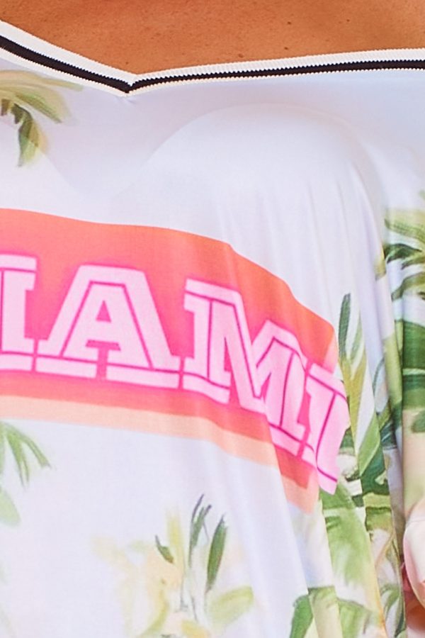 Un vestido elástico que tiene escote en pico, manga corta, es de punto frío y su estampado cubre toda la prenda.