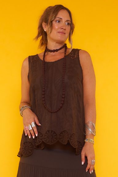 Una blusa sin mangas que tiene detalles con textura esparcidos y diseño de crochet en sus tirantes y parte inferior.