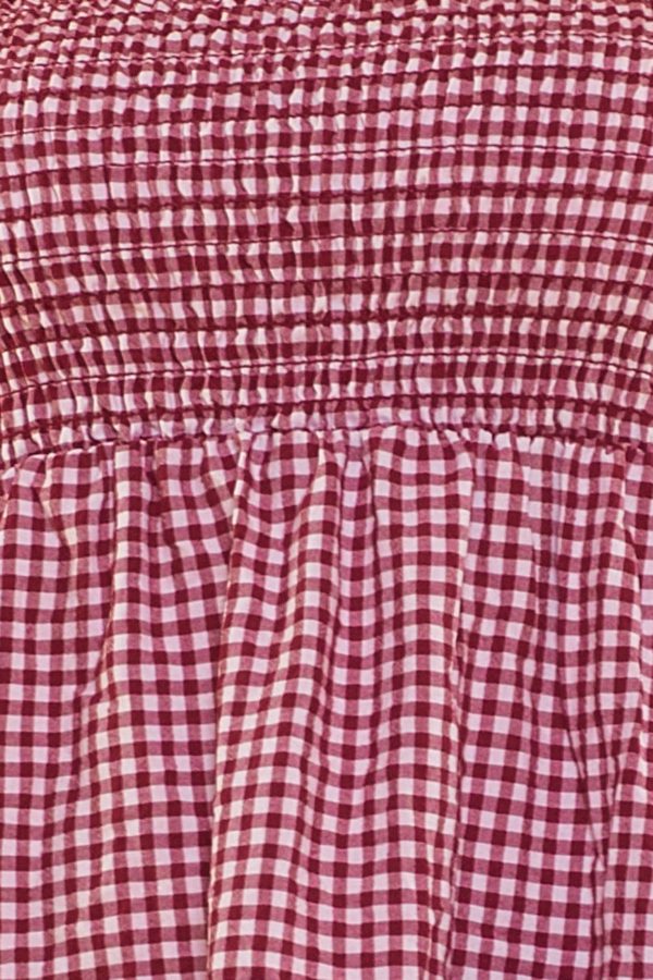 Un vestido corto de tirantes fijos que tienen volantes. Tiene nido de abeja en la parte superior, siendo elástico en esa área.