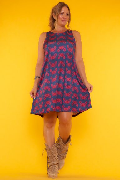 Un vestido corto elástico que tiene un estampado que cubre toda la prenda. No tiene mangas y su tejido es punto frío.