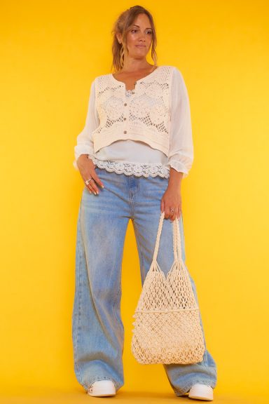 Una blusa corta de crochet con manga larga que se puede abrir o cerrar por medio de botones. Las mangas tienen distinto tejido al resto.