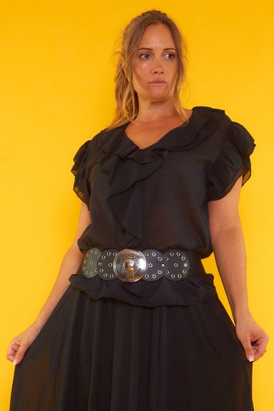 Una blusa de manga corta que tiene un tejido extremadamente suave y ligero. La prenda tiene volantes en todo su escote y en sus mangas.