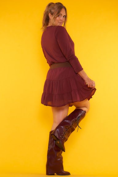 Una falda corta que tiene forro interior, goma elástica en la cintura y cordones para hacer un nudo decorativo.