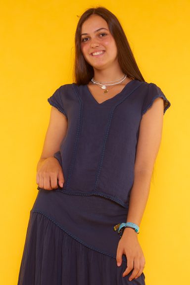 Una blusa de manga corta que tiene escote en pico y un corte asimétrico, teniendo su parte trasera más larga que la frontal.