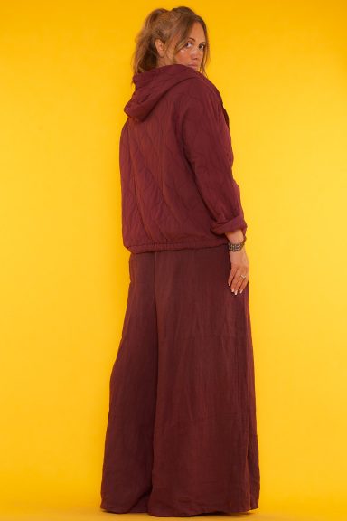 Un pantalón de pierna ancha que tiene bolsillos laterales, una goma elástica en la cintura y unas aperturas decorativas en su inferior.